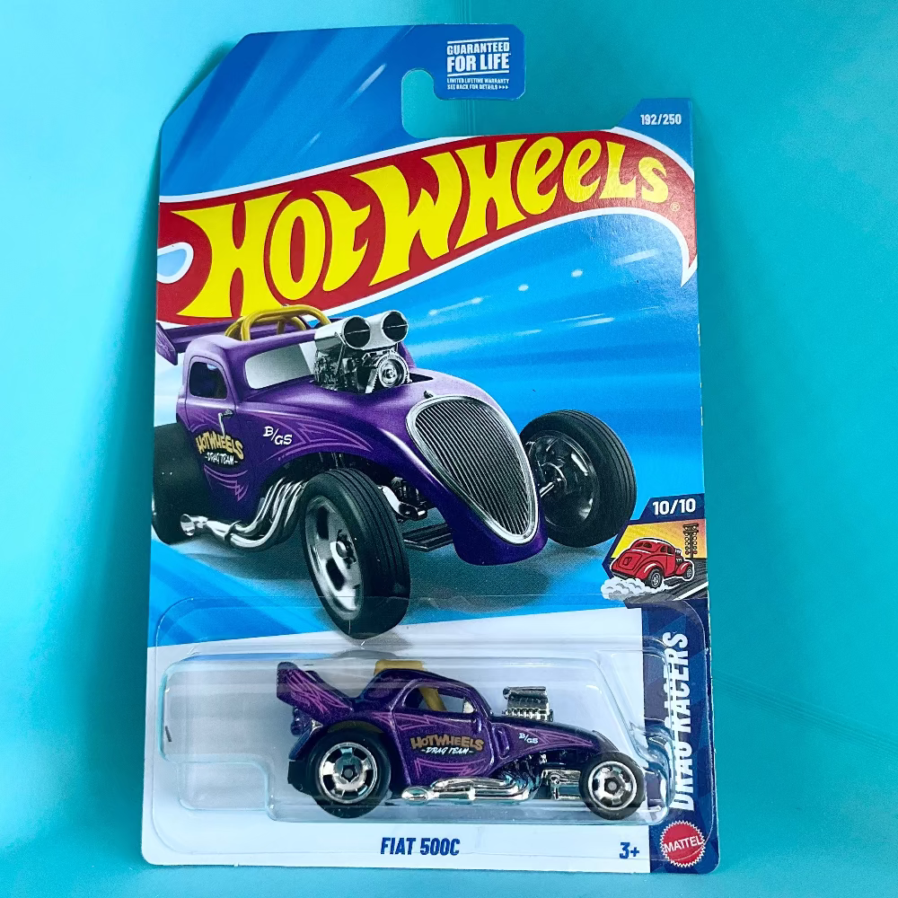 A Hot Wheels Mini Racers Fiat 500C toy car in its original blister card packaging, displayed against a bright turquoise background. The toy car is metallic purple with chrome details.