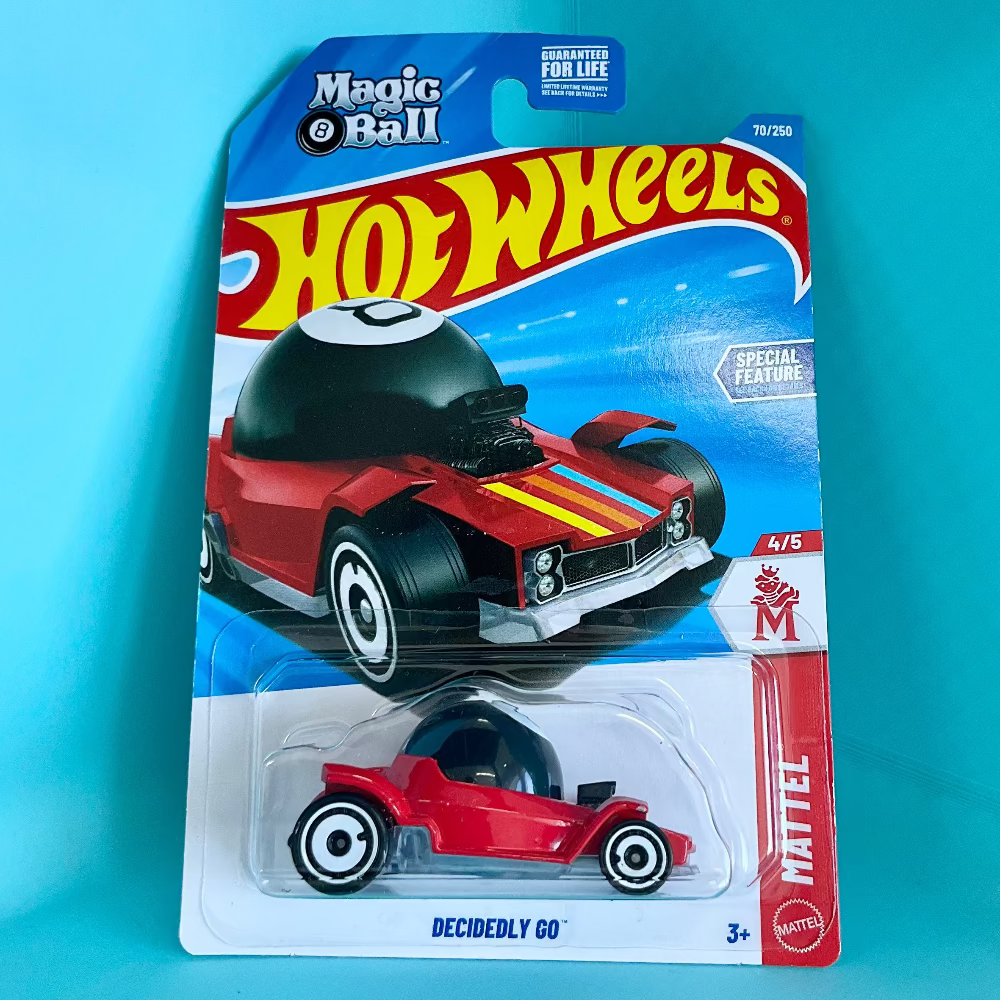 Hot Wheels Decidely Go toy car in its original Magic 9 Ball blister packaging, set against a bright cyan background.