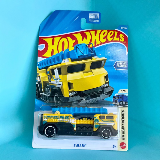 A Hot Wheels '5 Alarm' WW Heavyweights die-cast toy truck in its original blister card packaging, set against a solid light blue background.