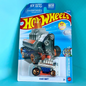 A packaged Hot Wheels die-cast toy car labeled 'Click Shift' on a blue and white blister card, photographed against a bright cyan background.