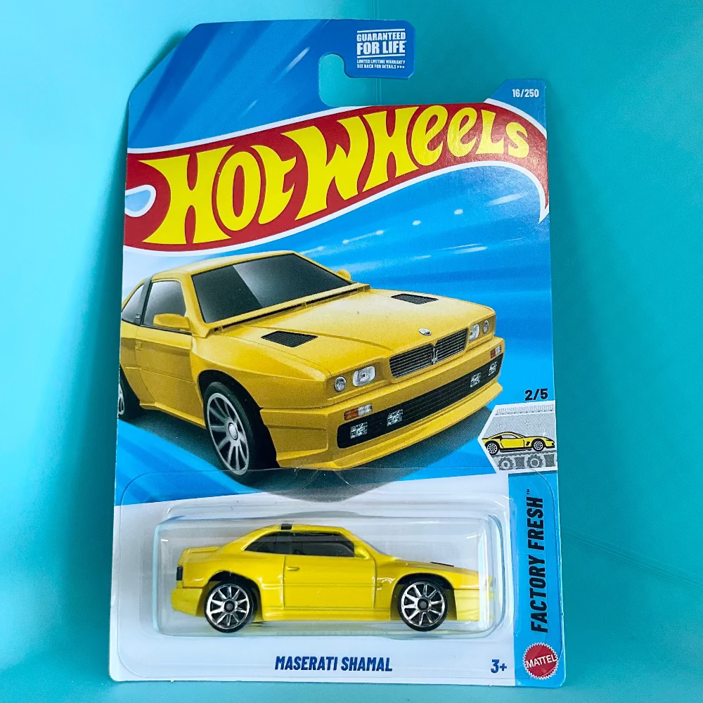 A Hot Wheels Maserati Shahal die-cast toy car in its original blister card packaging, displayed against a bright turquoise background.