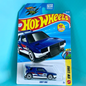 A Hot Wheels Drift Box toy car in its original blister card packaging, displayed against a bright turquoise background. The packaging features the classic Hot Wheels logo and depicts a blue and white drift car.