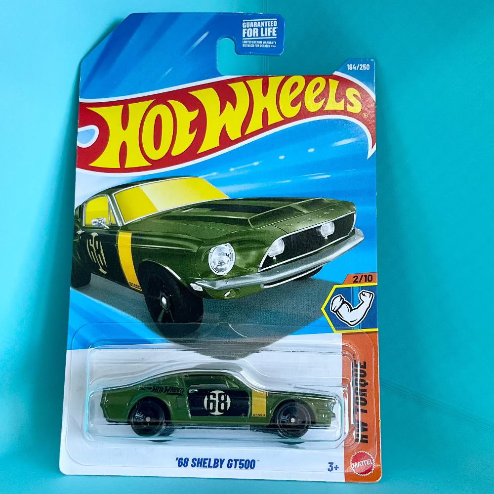 A Hot Wheels '68 Shelby GT500 die-cast toy car in its original blister card packaging, displayed against a solid turquoise background.